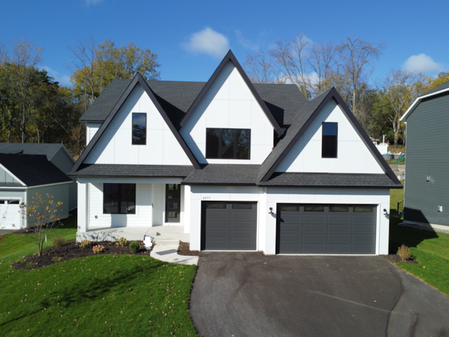 modern inspired farmhouse with a front yard and a garage