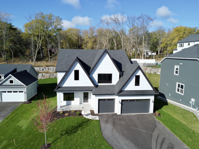 modern farmhouse with a garage and a front lawn