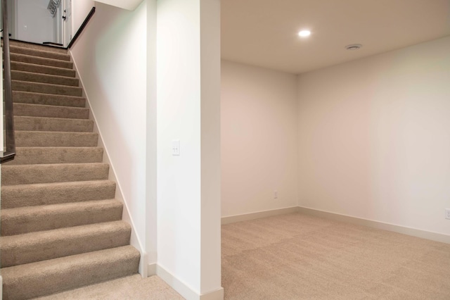 staircase featuring carpet flooring