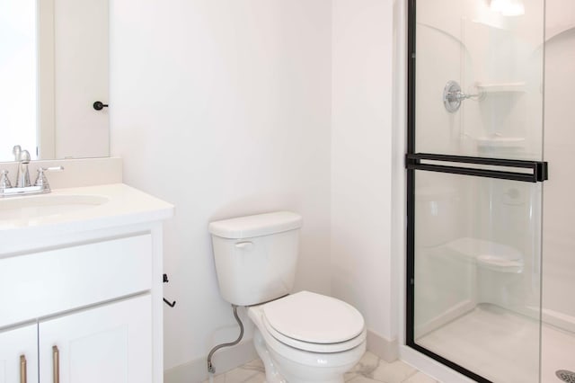 bathroom featuring vanity, a shower with shower door, and toilet