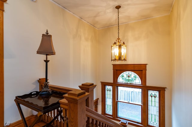 foyer featuring a chandelier and crown molding