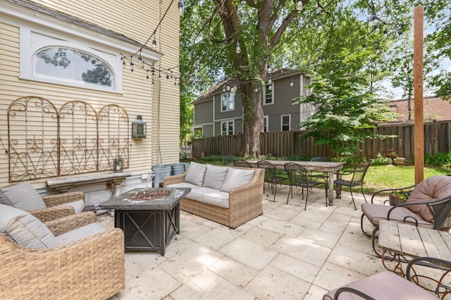 view of patio with an outdoor living space with a fire pit