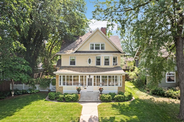 view of front facade with a front lawn and a sunroom