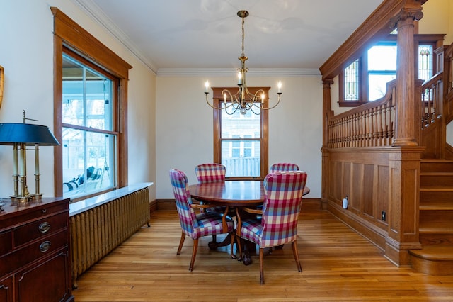 dining area with crown molding, a healthy amount of sunlight, and light hardwood / wood-style flooring