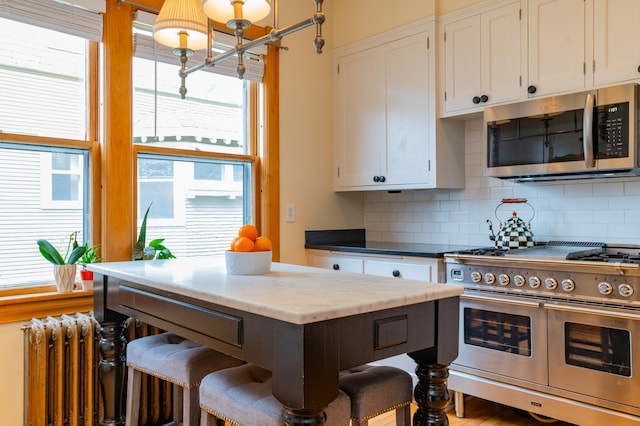 kitchen featuring white cabinets, stainless steel appliances, and tasteful backsplash