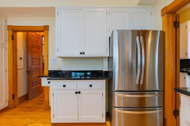 kitchen with white cabinets, light wood-type flooring, and stainless steel refrigerator