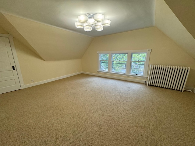 additional living space featuring radiator heating unit, carpet flooring, a notable chandelier, and lofted ceiling