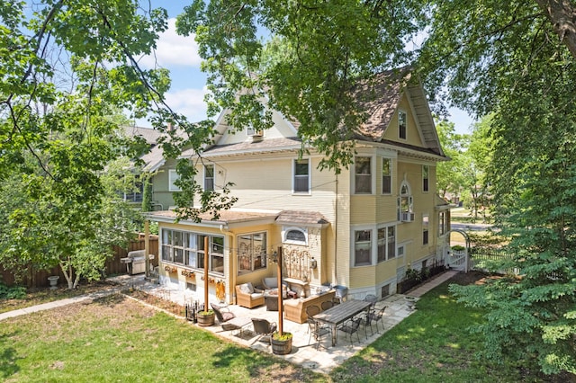 rear view of property featuring a patio, a lawn, and outdoor lounge area