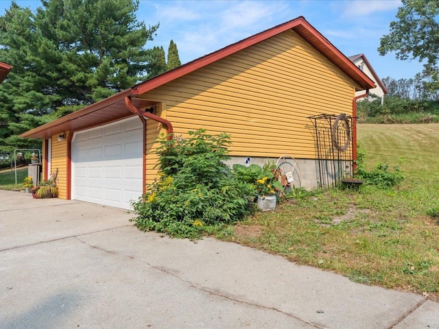 view of side of home with a lawn and a garage