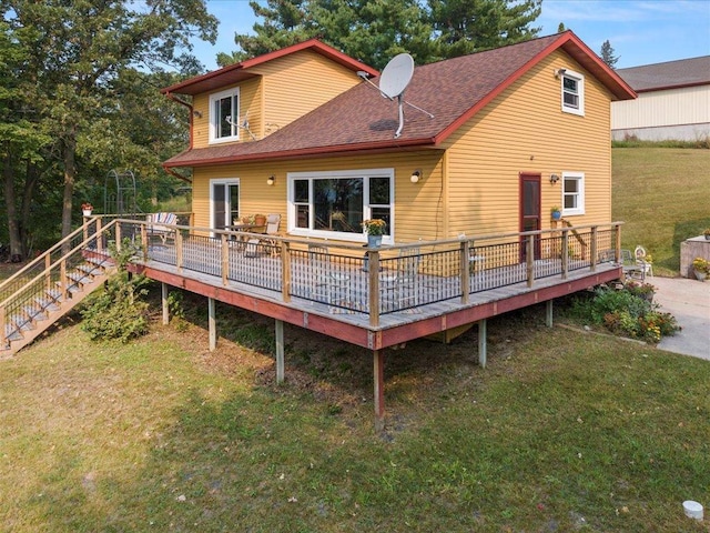 rear view of house with a deck and a yard