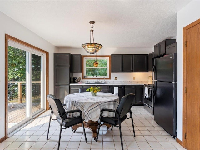 dining space featuring light tile patterned flooring, sink, and a textured ceiling