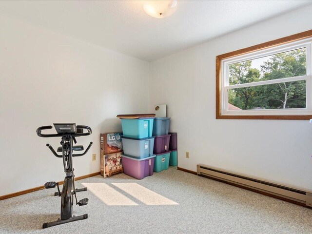 workout area featuring baseboard heating and carpet flooring