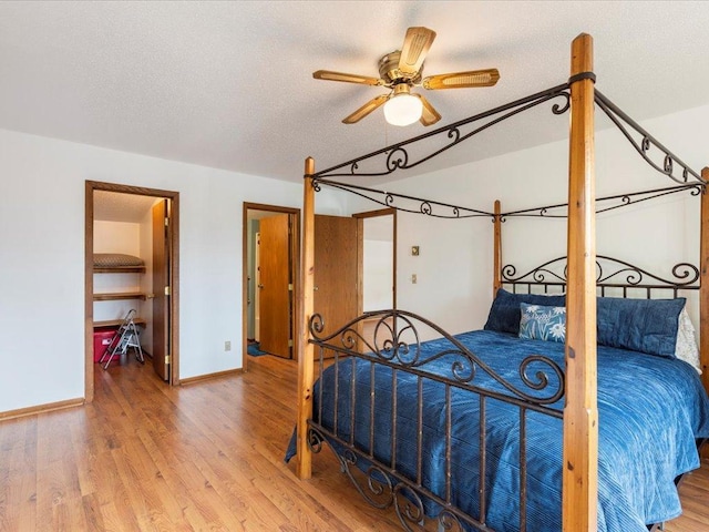 bedroom with ceiling fan, a textured ceiling, and hardwood / wood-style floors