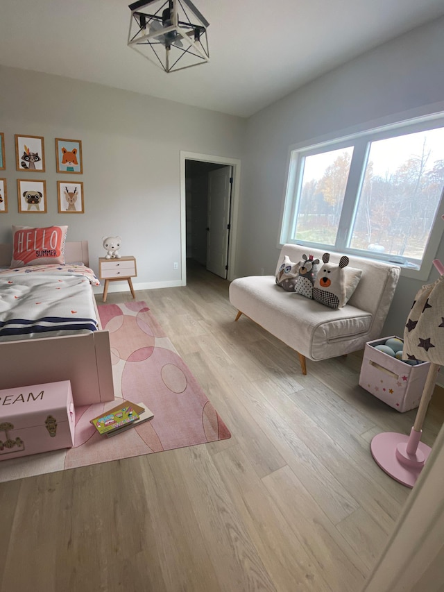 bedroom with wood-type flooring and an inviting chandelier