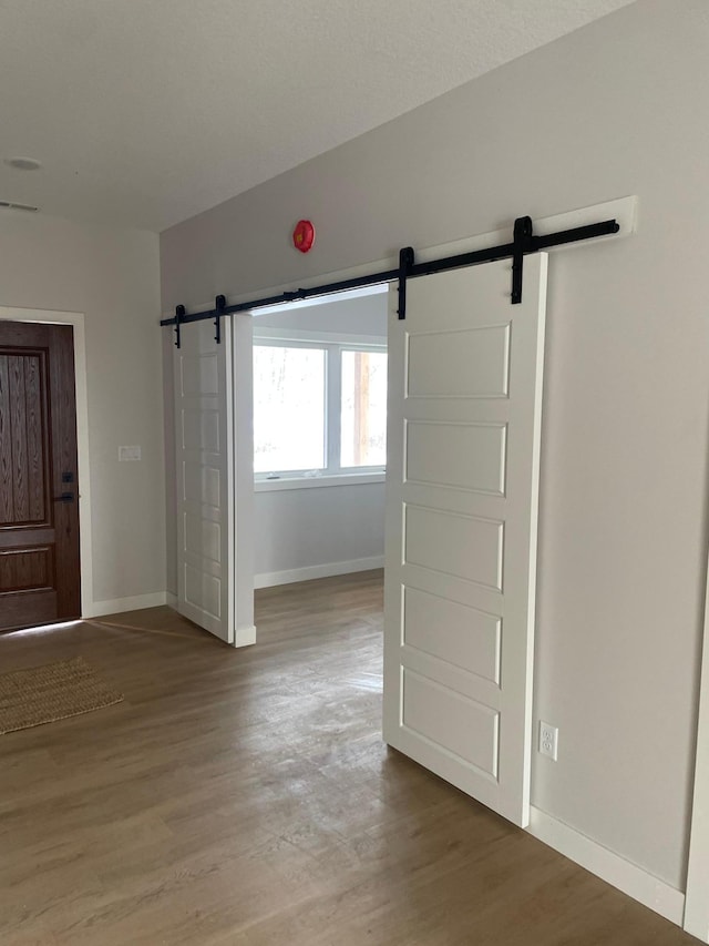 interior space with wood-type flooring and a barn door