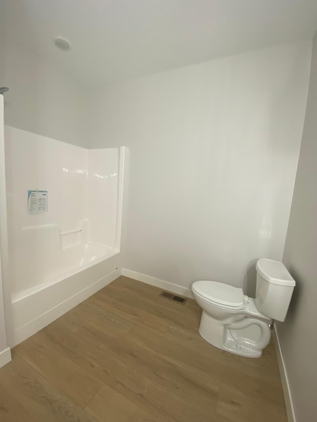 bathroom with toilet and hardwood / wood-style flooring