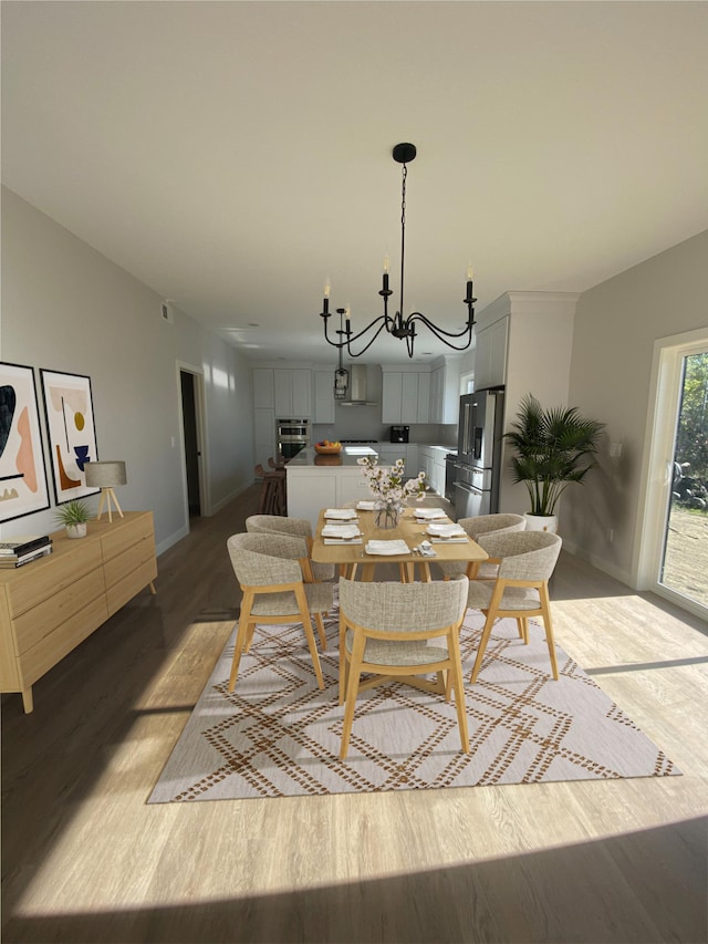 dining space with a chandelier and hardwood / wood-style flooring