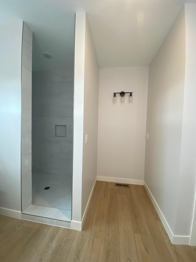 bathroom featuring tiled shower and hardwood / wood-style flooring