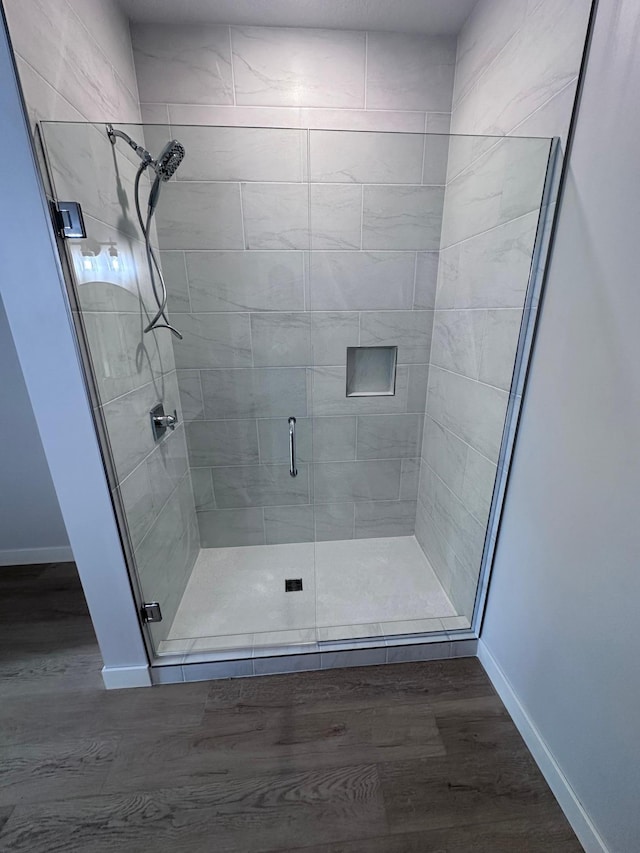 bathroom featuring a shower with door and hardwood / wood-style floors