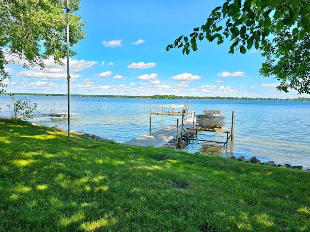 dock area with a water view and a lawn