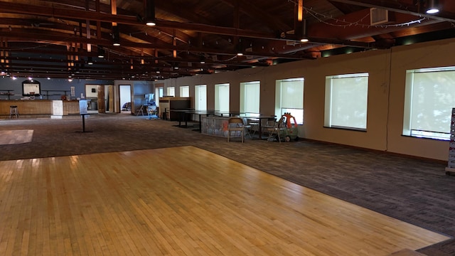 miscellaneous room featuring high vaulted ceiling, beamed ceiling, and hardwood / wood-style floors