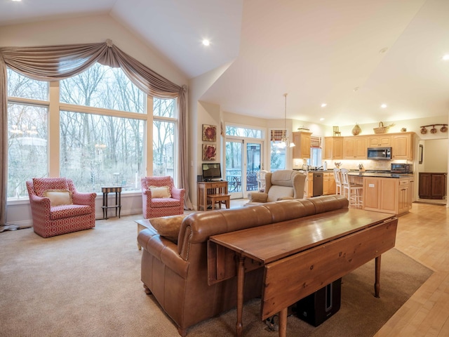 living room with high vaulted ceiling, light wood-type flooring, and a wealth of natural light