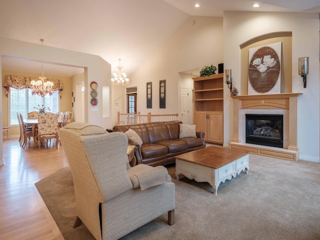 living room featuring light hardwood / wood-style floors, high vaulted ceiling, and a notable chandelier