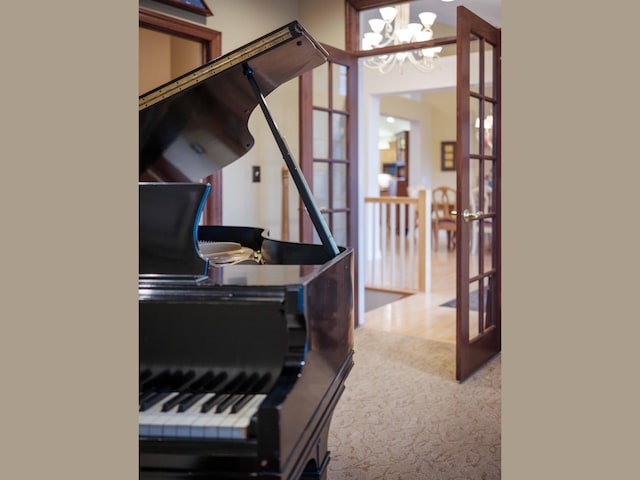 miscellaneous room featuring carpet flooring, french doors, and an inviting chandelier