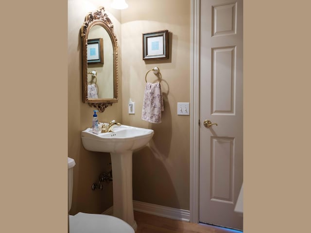 bathroom featuring hardwood / wood-style floors and toilet