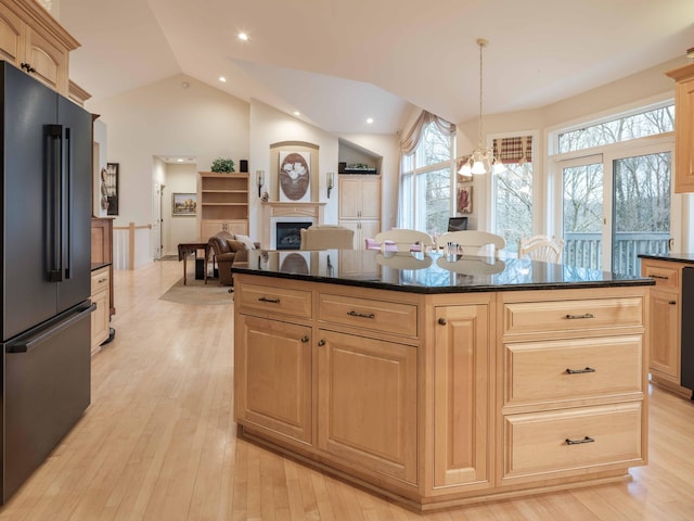 kitchen with vaulted ceiling, a wealth of natural light, light hardwood / wood-style flooring, and fridge