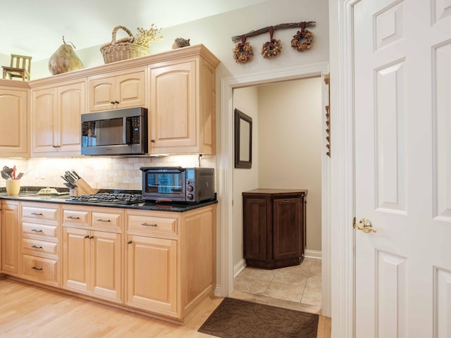 kitchen with decorative backsplash, appliances with stainless steel finishes, light wood-type flooring, and light brown cabinets