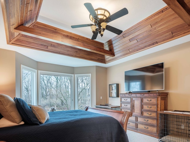 bedroom featuring ceiling fan, carpet floors, and a tray ceiling