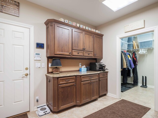 kitchen with light tile patterned flooring and light stone countertops