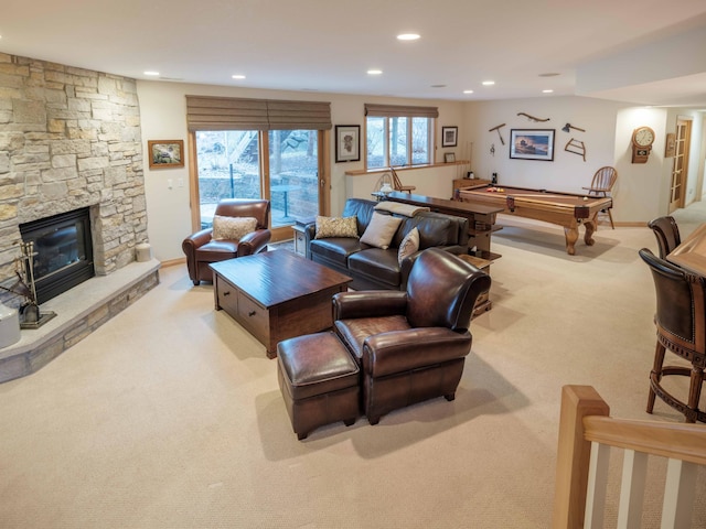 living room featuring light colored carpet, a fireplace, and pool table