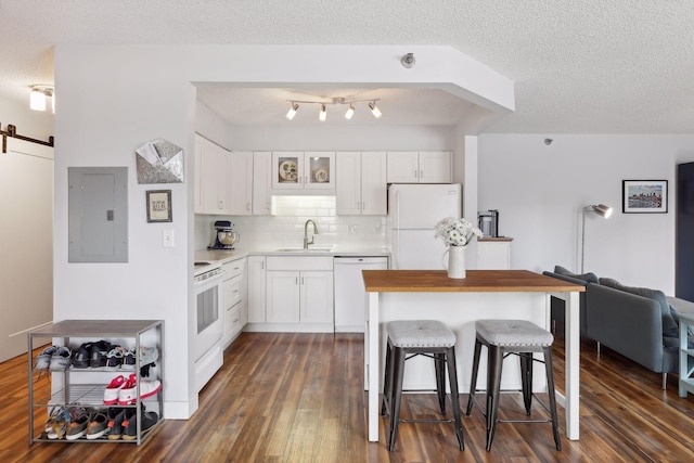 kitchen featuring sink, white appliances, white cabinetry, and a barn door