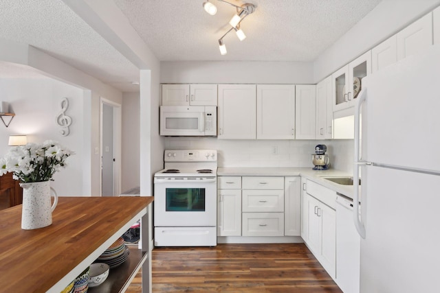 kitchen featuring rail lighting, white appliances, a textured ceiling, white cabinets, and dark hardwood / wood-style flooring