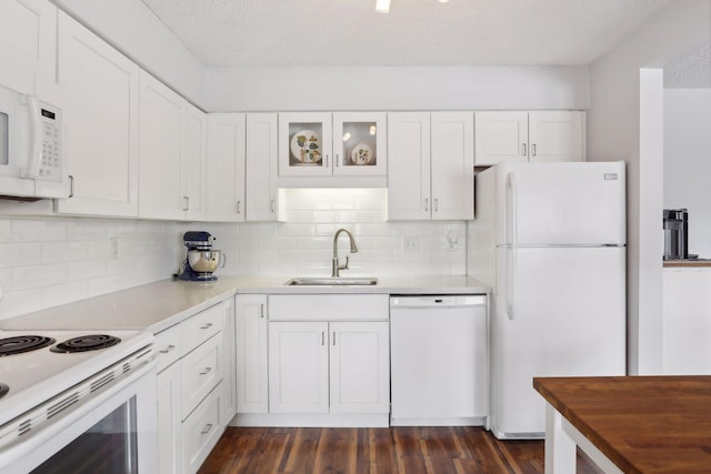 kitchen with white cabinetry, dark hardwood / wood-style floors, white appliances, and sink