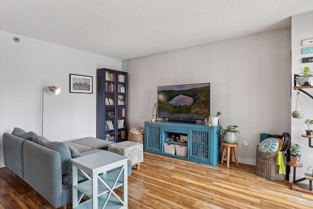 living room with light hardwood / wood-style floors and a textured ceiling