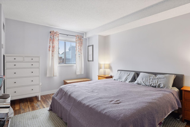 bedroom featuring dark hardwood / wood-style floors and a textured ceiling