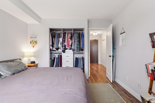 bedroom featuring dark wood-type flooring, a closet, and a textured ceiling