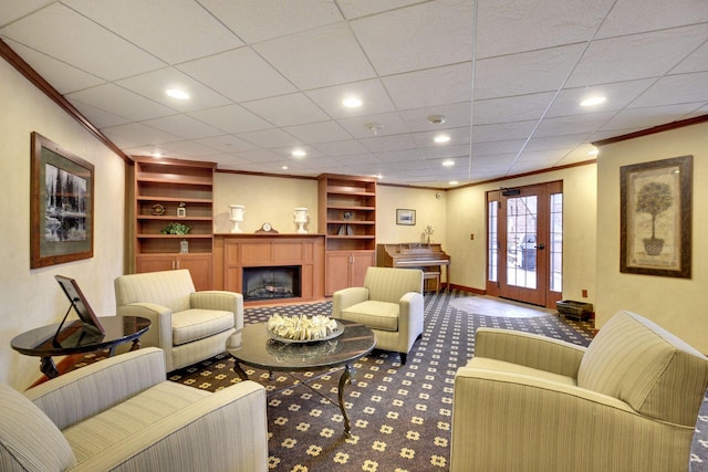 carpeted living room with french doors, ornamental molding, and built in features