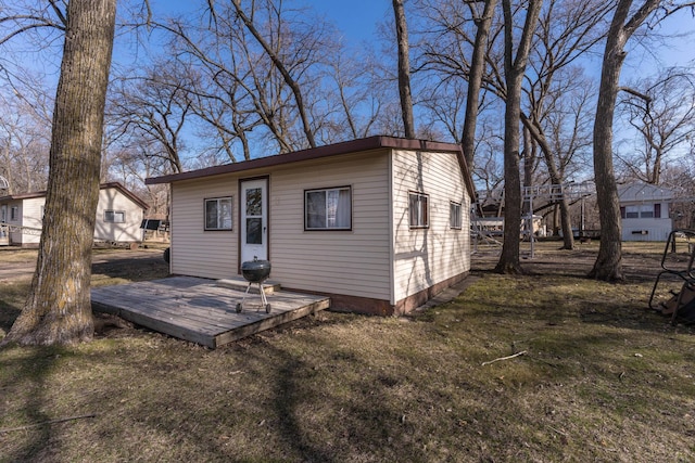 rear view of property with a deck and a yard