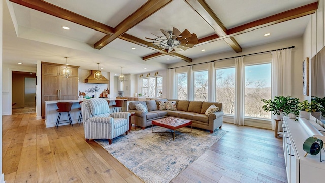 living room featuring beamed ceiling, ceiling fan, light wood-type flooring, and coffered ceiling