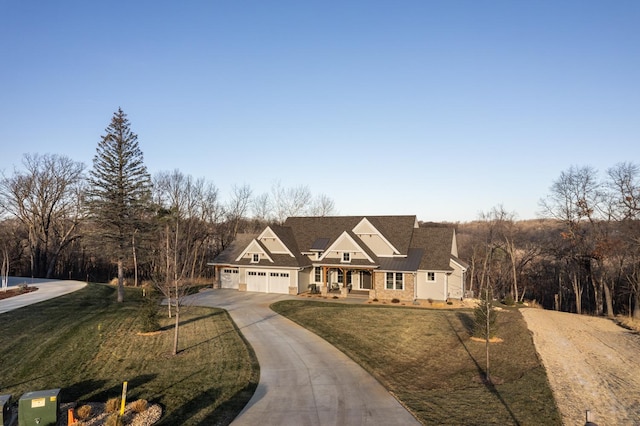 view of front of home with a front lawn, covered porch, and a garage