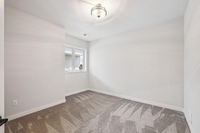 empty room featuring carpet and a textured ceiling