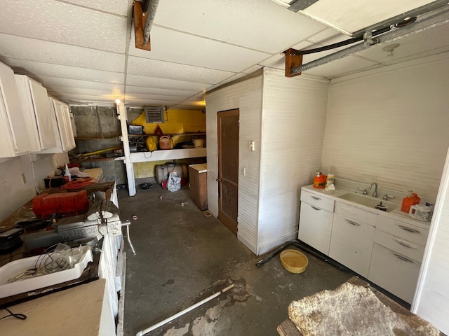 interior space featuring a drop ceiling and sink