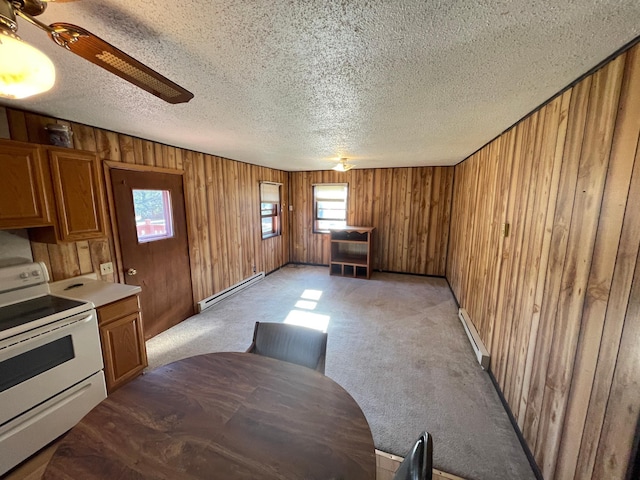 kitchen featuring carpet, electric range, a baseboard radiator, and wood walls