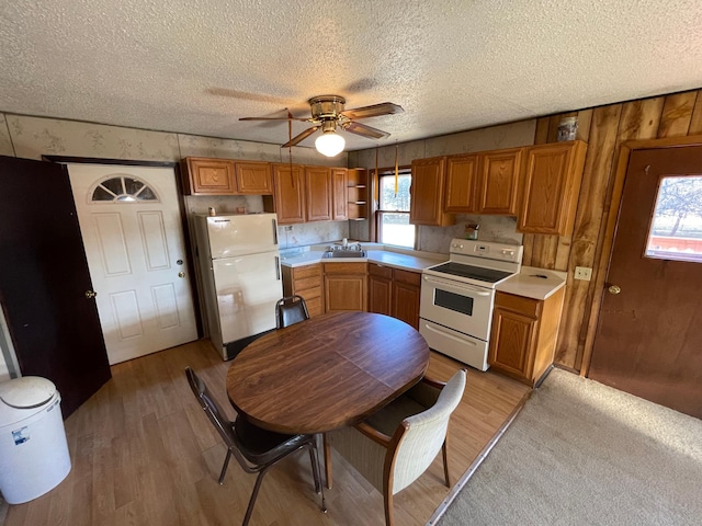 kitchen featuring a textured ceiling, ceiling fan, light hardwood / wood-style floors, and white appliances