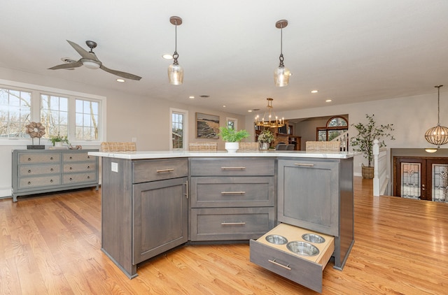 kitchen featuring gray cabinets, a center island, light hardwood / wood-style flooring, and decorative light fixtures