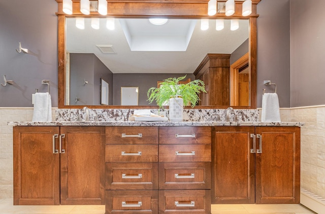 bathroom featuring vanity, tile walls, and a tray ceiling